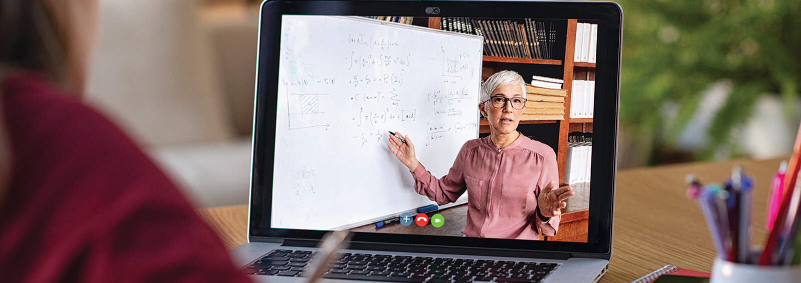 Banner A teacher watches another teacher on her computer.